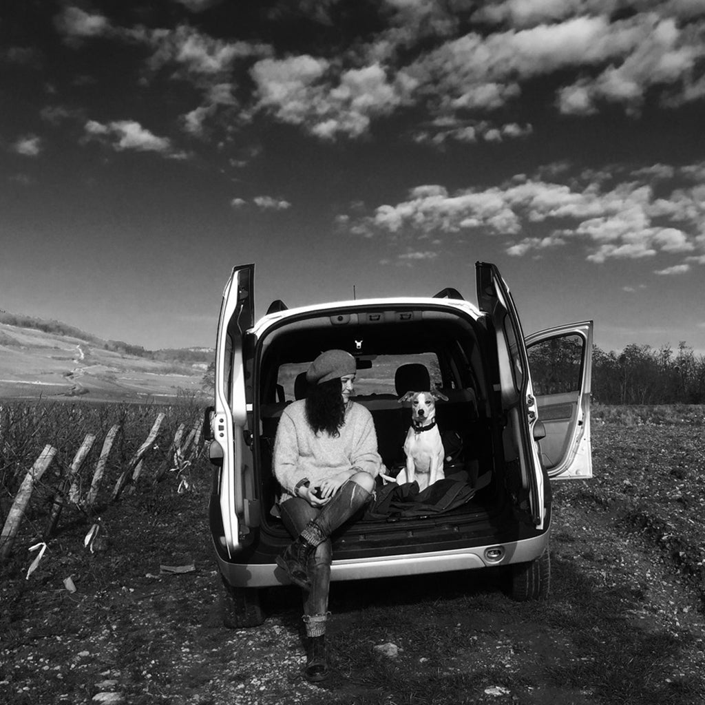 Fiona Leroy & her dog Lulu sat in the back of a van amongst the vines