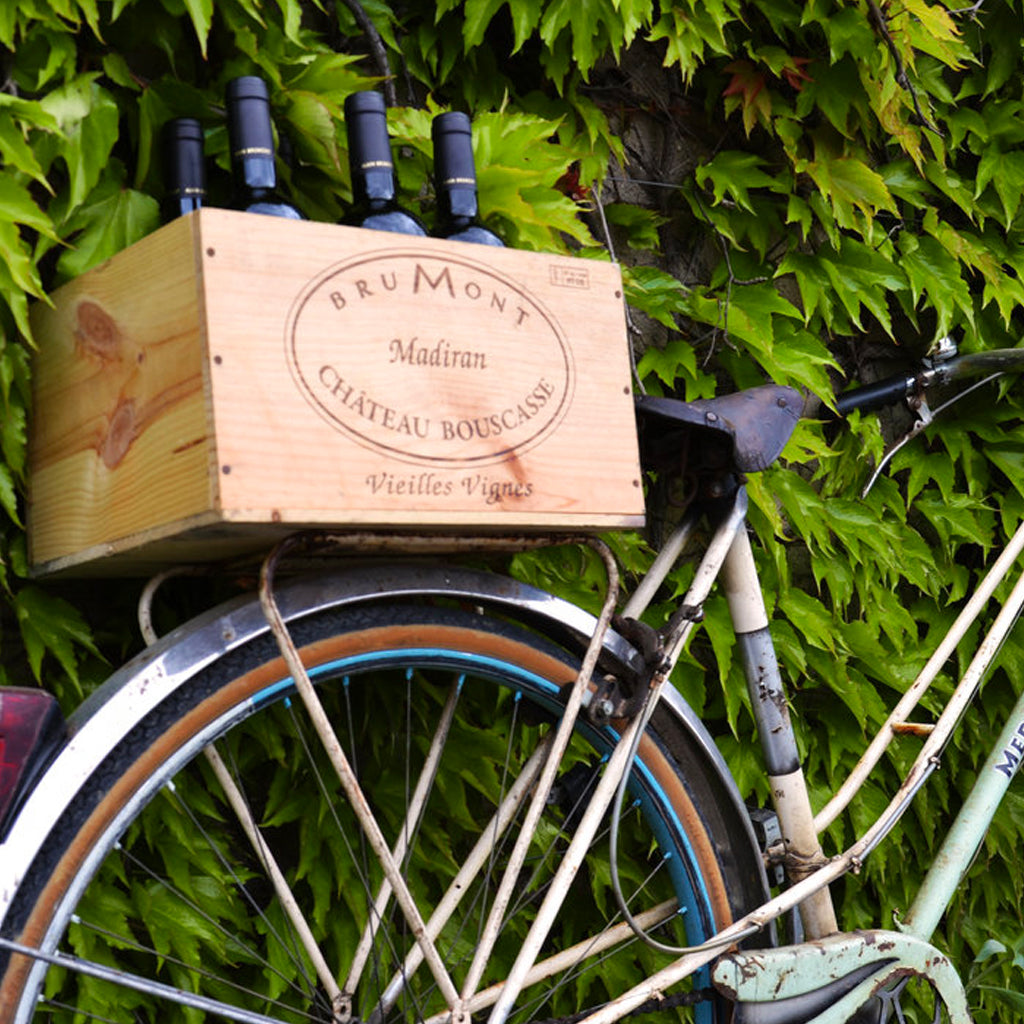 Bottles of Château Bouscassé Madiran in wooden box on the back of a bicycle