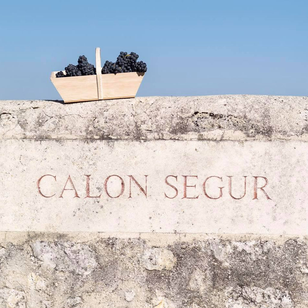 Calon Segur Marker Stone in Stone Wall with Basket of Grapes atop.
