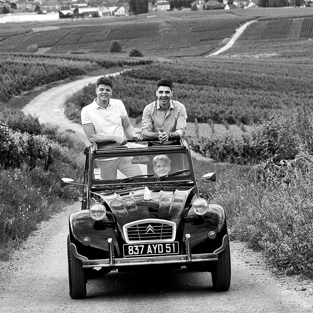Emmanuel & Charles-Henry Fourny Stood Up in open top Citroen 2cv car driven through champagne vineyards