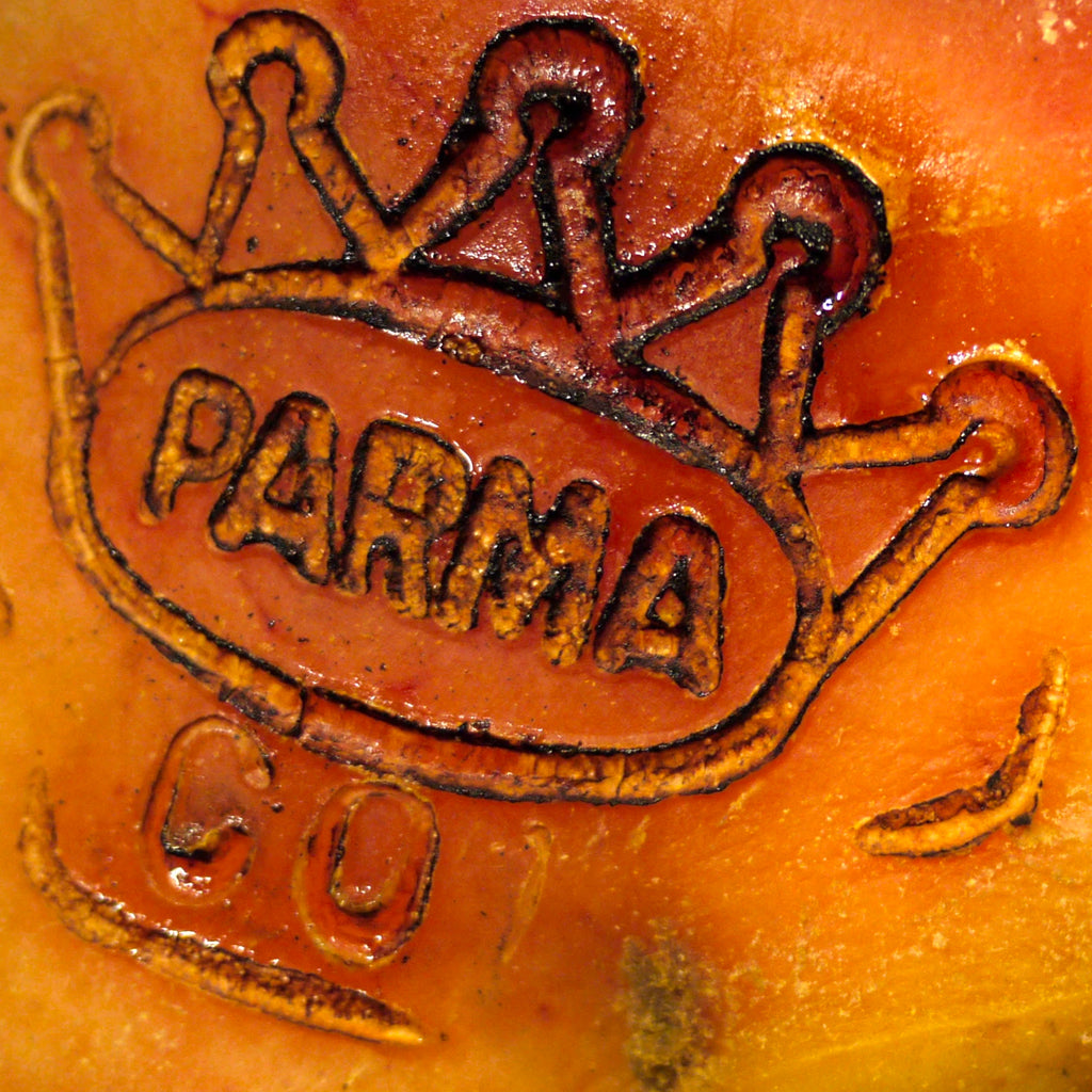 A close-up of the official PARMA Ham logo stamped onto a cured parma ham leg.